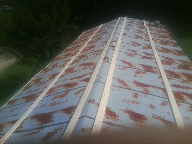 Rusted metal roof panels with new wood purlins before replacement — Storm Damage Roof Repair in Hardy by Roofing Brothers