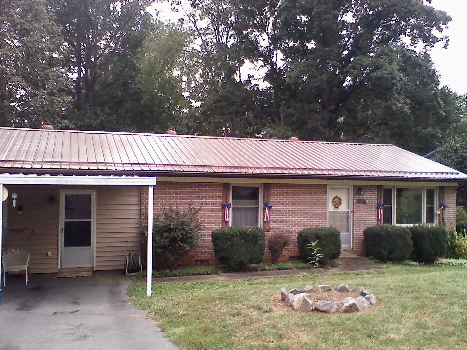 Bronze metal roof and carport on a brick ranch home — Roof Repair work by our crew in Hardy